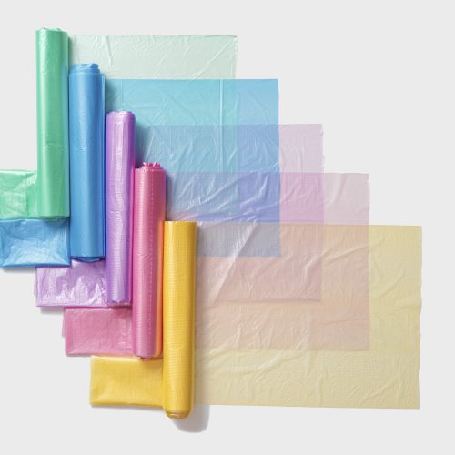 Colorful plastic bags in rolls as geometric pattern on white background. Eco plastic product bio bags for food, Plastic free environment protection concept, eco trend to reduce disposable plastic